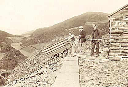 Photograph: Goleuwern Quarry, Friog - Top of main incline, loaded train about to descend controlled by E.J. Meredith (Manager) with hand on the brake. Mr Abel Simner (Owner) standing nearby.