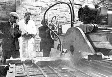 Photograph: A machine sawing a block of slate.