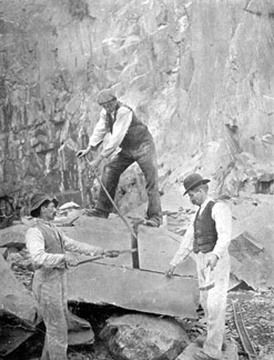 Quarrymen splitting slate into blocks.