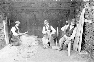 A team of quarrymen splitting slates